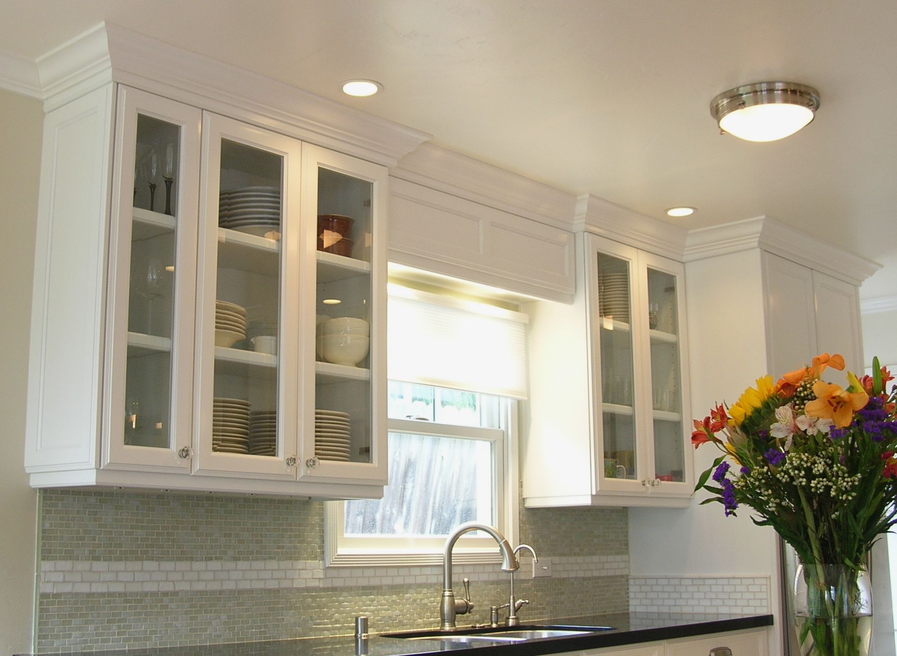 custom_cabinets_with_glass_fronts_and_knobs_and_over-sink_lighting_3