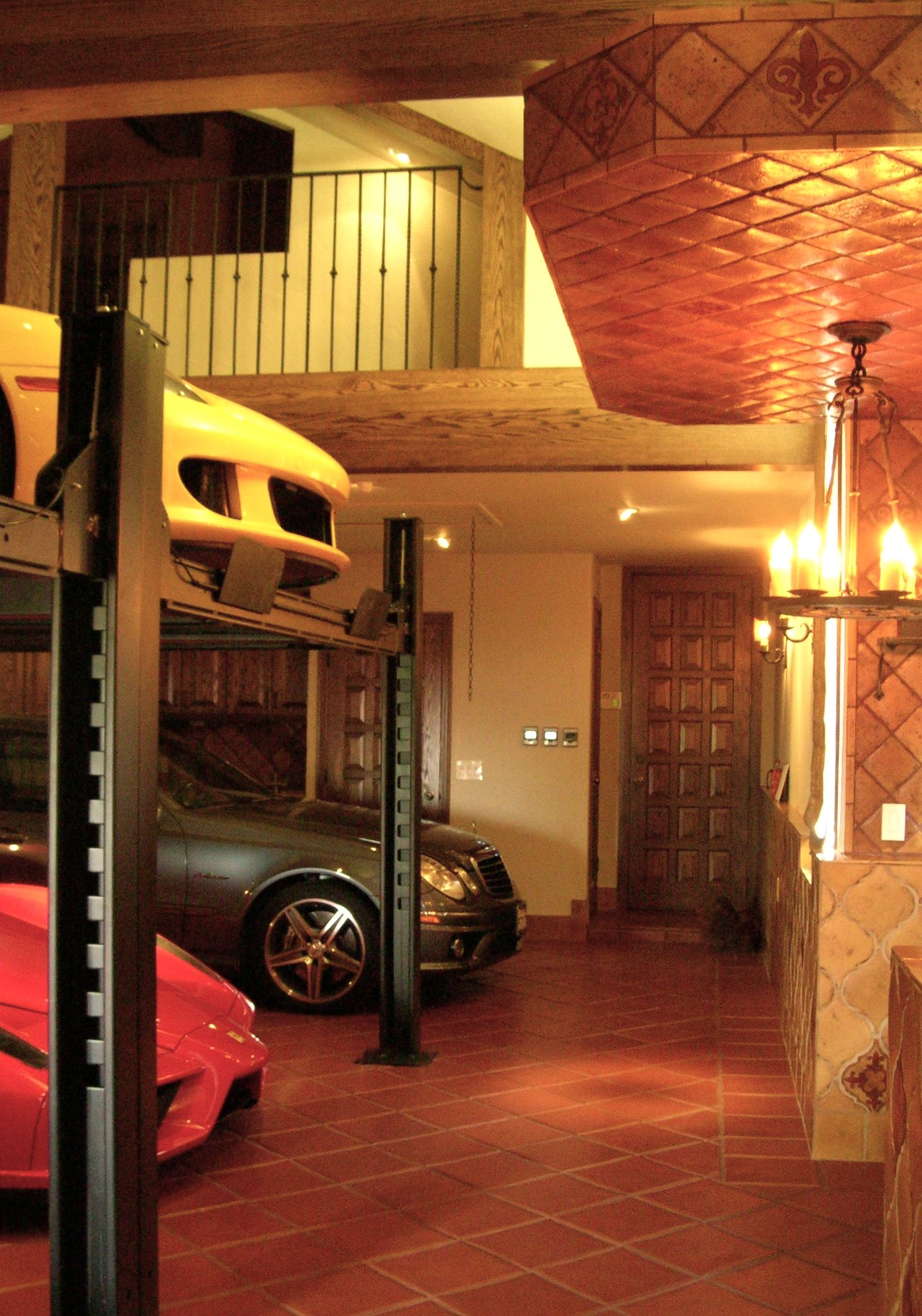 garage_showroom_and_entertainment_area_with_custom_tile_iron_work_light_fixtures_and_car_lifts_3